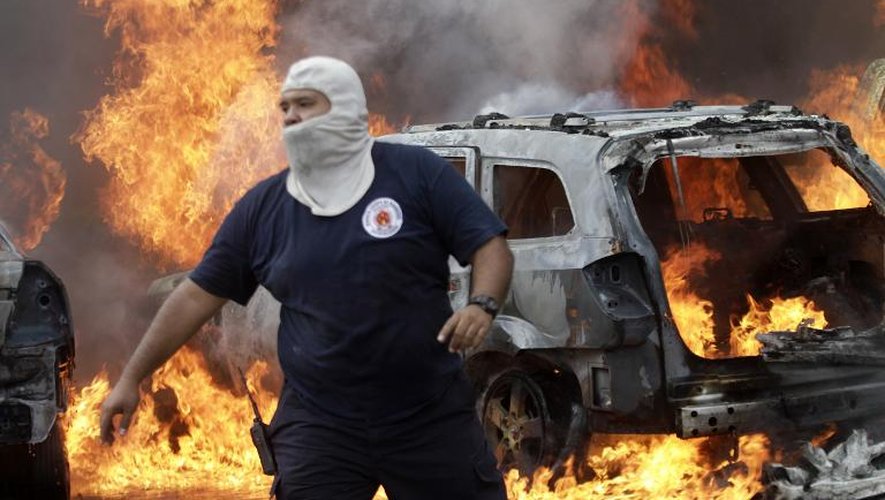 Un pompier devant un véhicule incendié par des manifestants, le 12 novembre 2014 à Chilpancingo, au Mexique