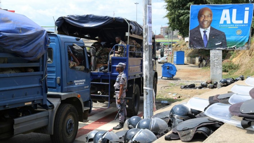 Des forces de sécurité gabonaises devant une affiche du président Ali Bongo à Libreville le 23 septembre 2016