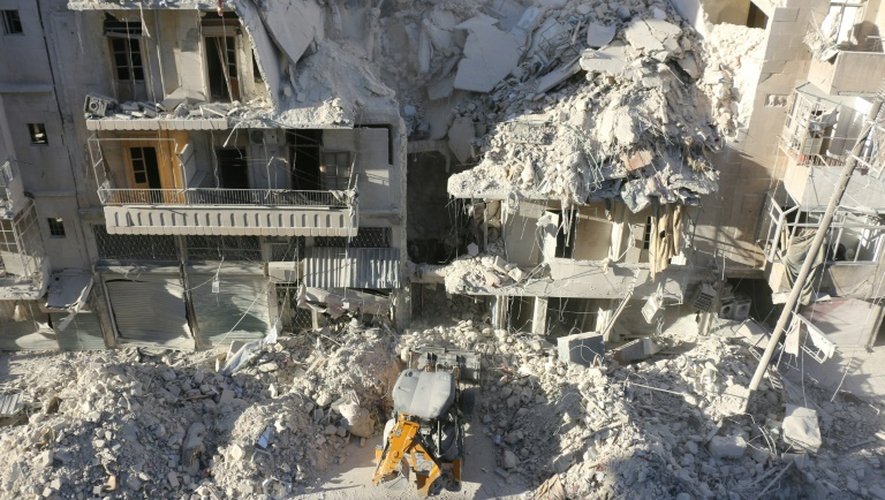 Un tracteur déblaye les ruines d'un immeuble détruit par une frappe aérienne dans un quartier rebelle d'Alep, le 24 septembre 2016
