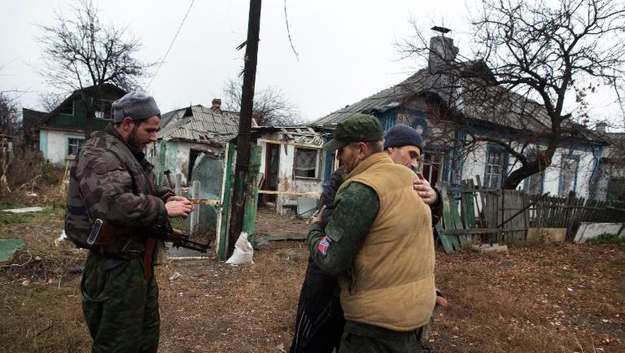 Des rebelles prorusses saluent un résident dans le quartier d'Oktyaber au nord-ouest de Donetsk, le 13 novembre 2014