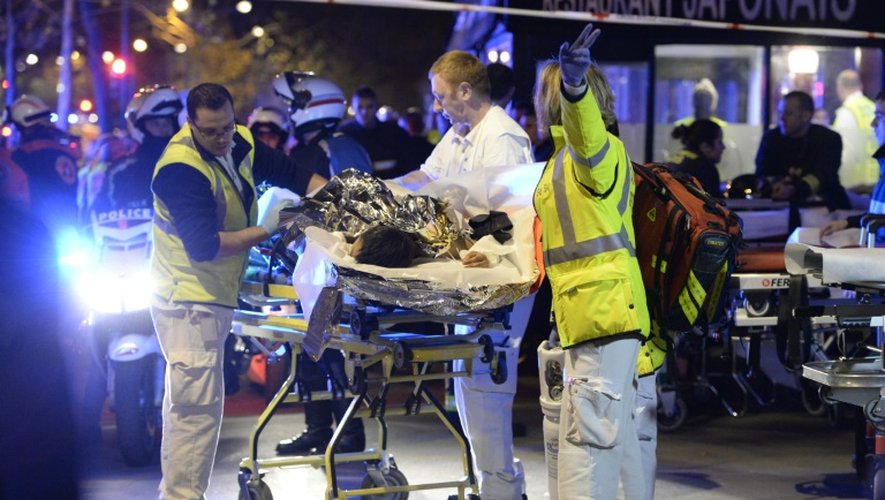 Des secouristes évacuent une personne blessée lors de l'attaque terroriste contre la salle de concert du Bataclan, le 13 novembre 2015, à Paris