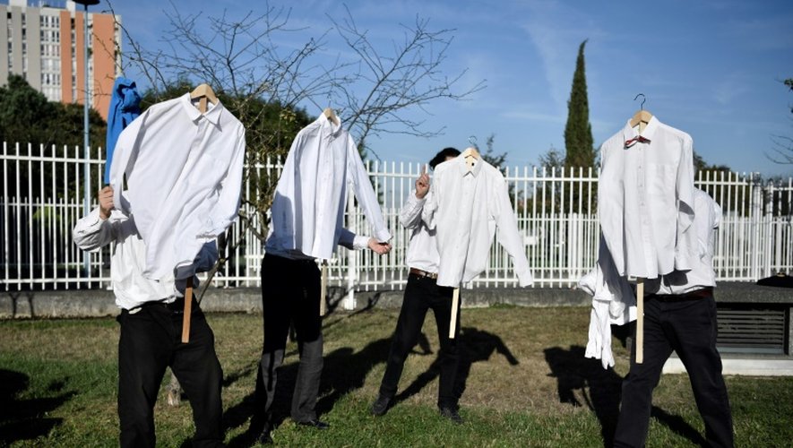 Les membres d'une petite troupe de théâtre brandissent des chemises blanches en parfait état devant le tribunal de Bobigny, près de Paris, où sont jugés 15 salariés de la compagnie Air France, le 27 septembre 2016