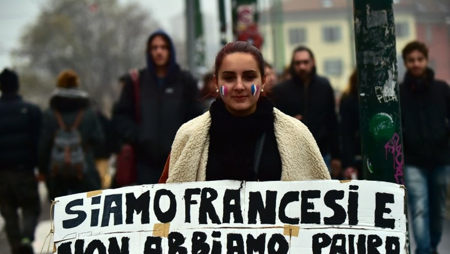 Une femme porte une affiche proclamant en italien "Nous sommes français et nous n'avons pas peur" lors d'un rassemblement à Milan, le 14 novembre 2015