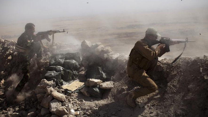 Des combattants kurdes peshmergas tirent sur des positions de jihadistes, depuis le Mont Zardak, près de Mosul, le 9 septembre 2014 en Irak