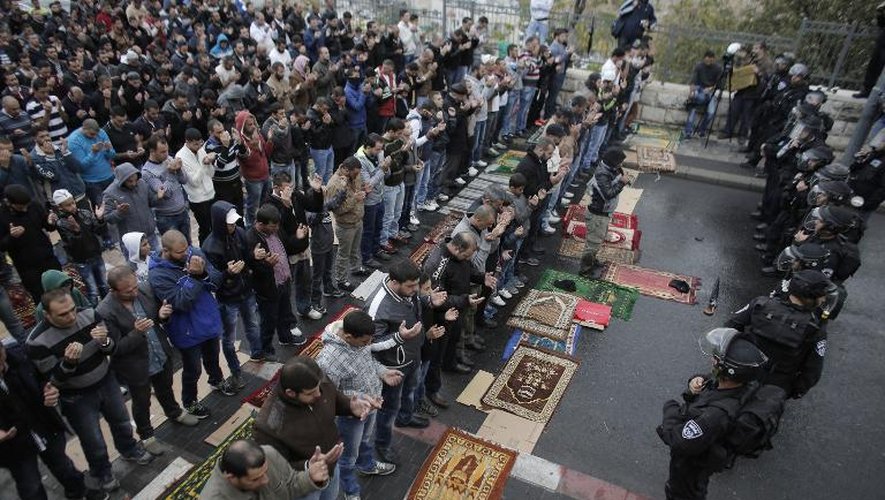 Des forces de sécurité israéliennes face à un groupe de Palestiniens participant à la prière du vendredi dans une rue de Jérusalem-Est, le 31 octobre 2014
