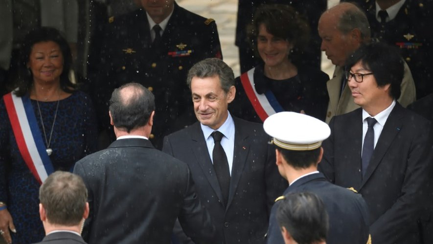 Le président Hollande salue Nicolas Sarkozy, lors d'une cérémonie aux Invalides à l'occasion de la Journée nationale d'hommage aux harkis, le 25 septembre 2016 à Paris