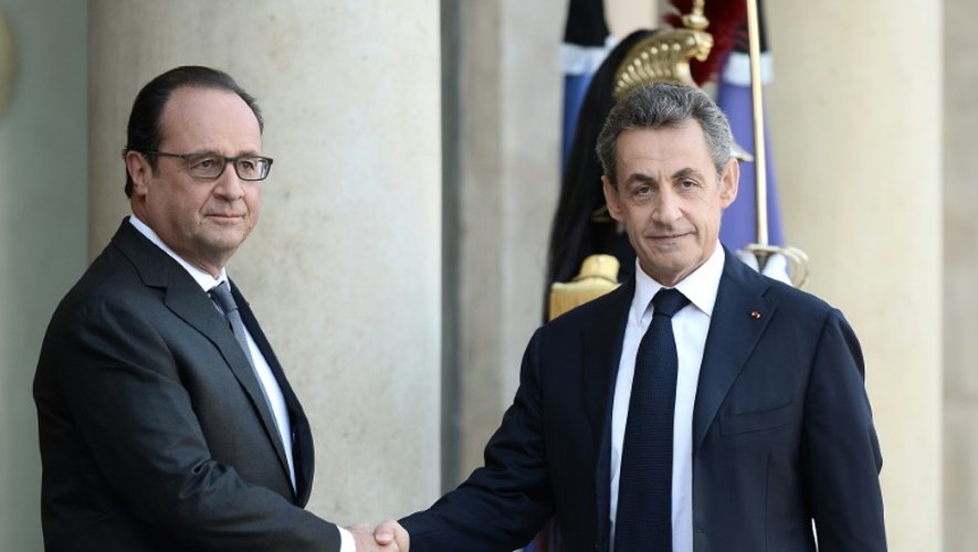 Le président français François Hollande (g) salue son prédécesseur à l'Elysée Nicolas Sarkozy à Paris le 15 novembre 2015