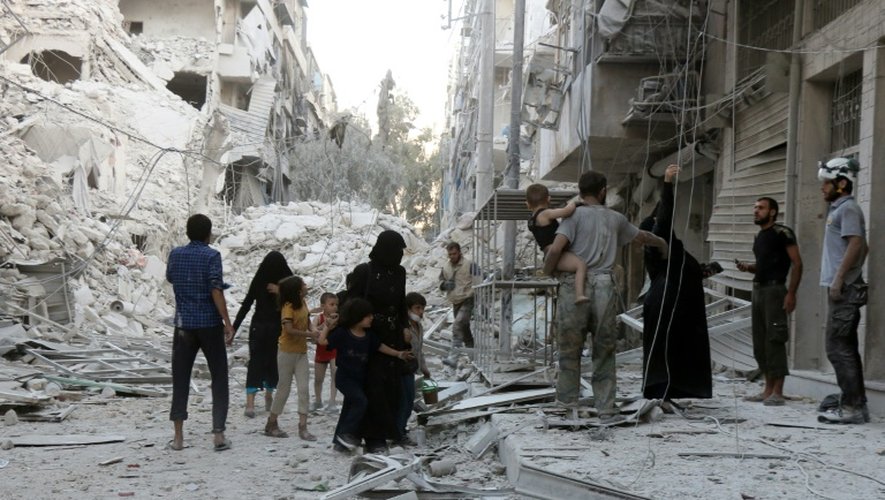 Des habitants quittent leur immeuble détruit par les bombardements syriens, le 23 septembre 2016 dans un quartier rebelle d'Alep, en Syrie