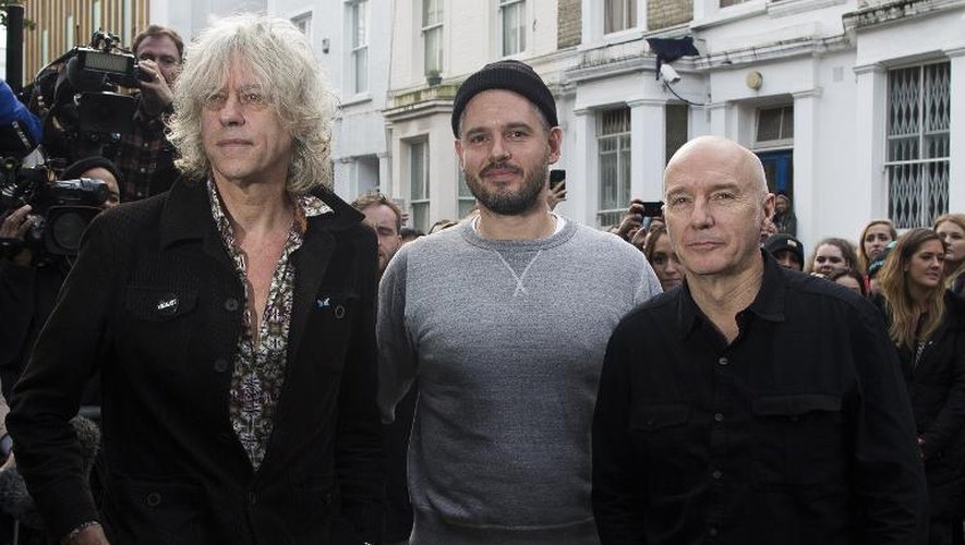 Le chanteur Midge Ure (G), le producteur Paul Epworth (C) et le chanteur irlandais Bob Geldof (D) devant le studio où ils doivent enregistrer une chanson pour Ebola, le 15 novembre 2014 à Londres