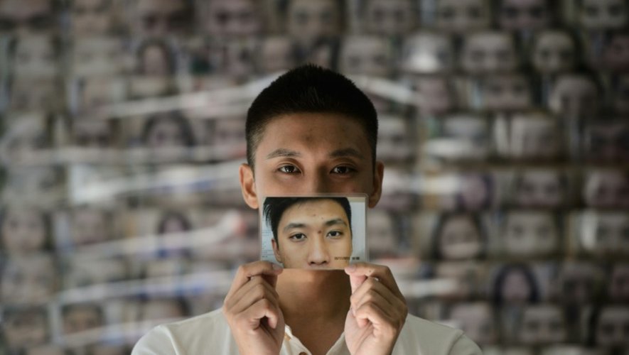 Un jeune homme montre une photo de lui-même et du changement de son visage après une épilation de ses sourcils, le 22 juillet 2016 à Hong Kong