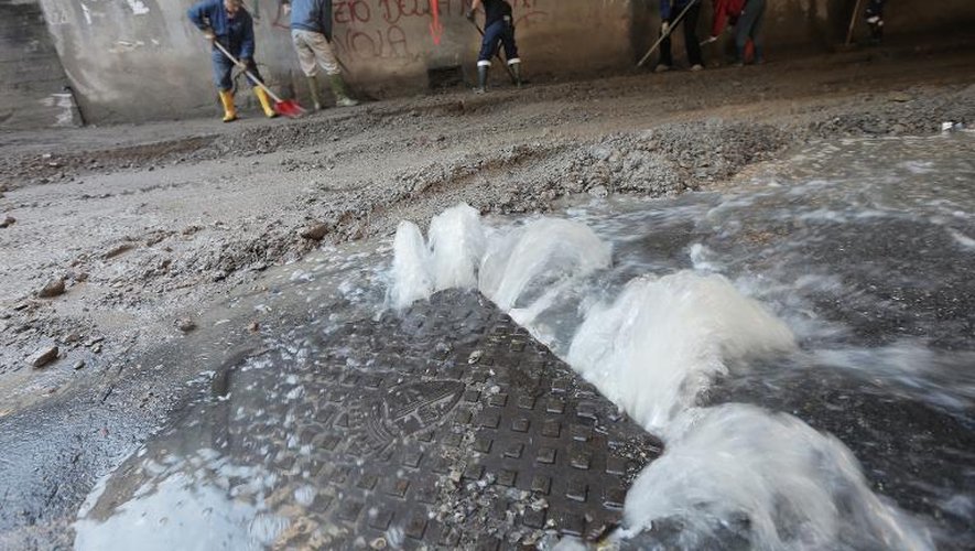 Des ouvriers réparent le 16 novembre 2014, une route détruites par des inondations Pontedecimo, en Italie