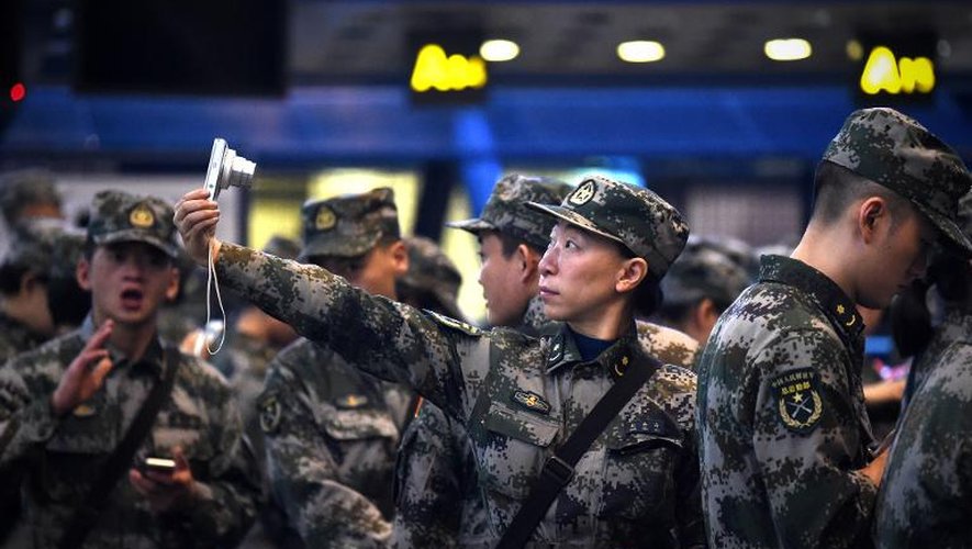 Un membre du contingent médical de l'armée chinoise se prend en photo avant son départ pour le Libéria à l'aéroport de Pékin, le 14 novembre 2014