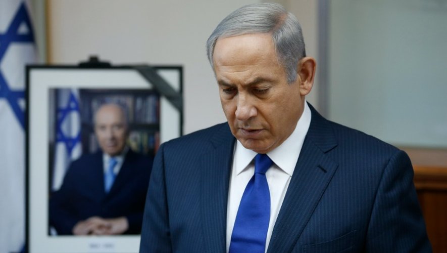 Le Premier ministre israélien Benjamin Netanyahu observe une minute de silence à proximité d'un portrait de Shimon Peres, décédé dans la nuit à l'âge de 93 ans, le 28 septembre 2016 à Jérusalem