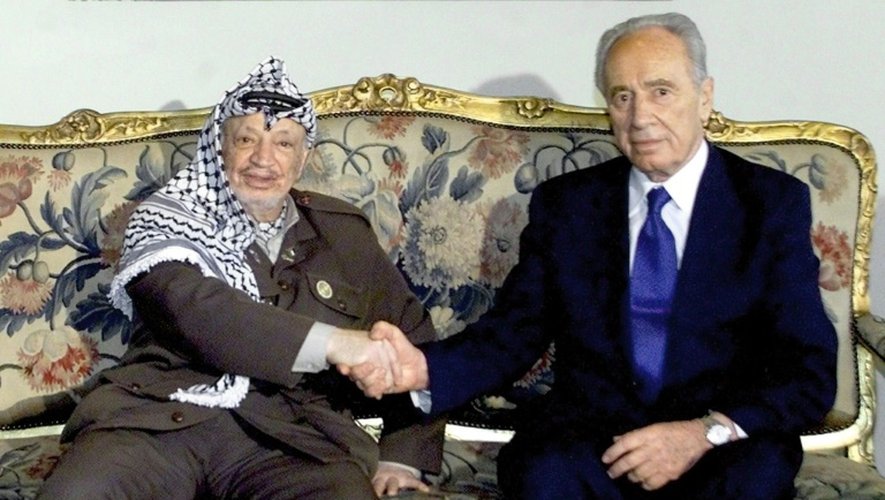 L'ancien leader de l'autorité palestinienne, Yasser Arafat, serre la main de Shimon Peres, au  Caire le 15 juillet 2001