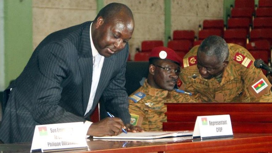 Le leader de l'opposition burkinabè Zephirin Diabre (G) signe la charte de transition aux côtés du lieutenant-colonel Isaac Zida à Ouagadougou, le 16 novembre 2014