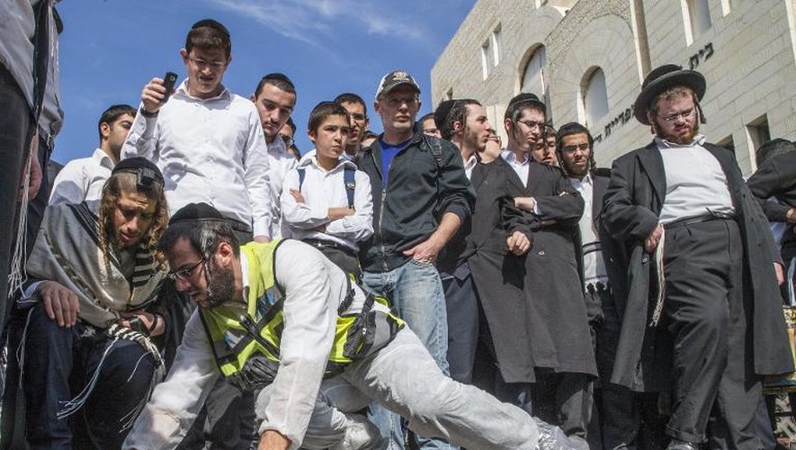 Des membres du personnel d'urgence nettoient le trottoir devant la synagogue à Jérusalem le 18 novembre 2014 où une attaque a fait 4 morts parmi les fidèles