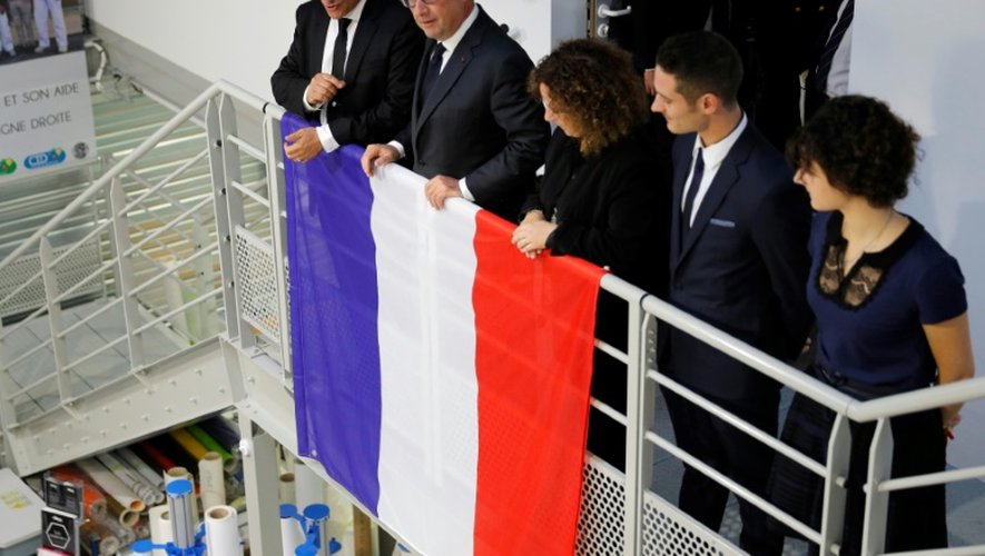 François Hollande entre Michel Catalano (G) et sa famille lors de l'inauguration le 29 septembre 2016 à Dammartin-en-Goele de son imprimerie détruite lors de l'assaut du GIGN
