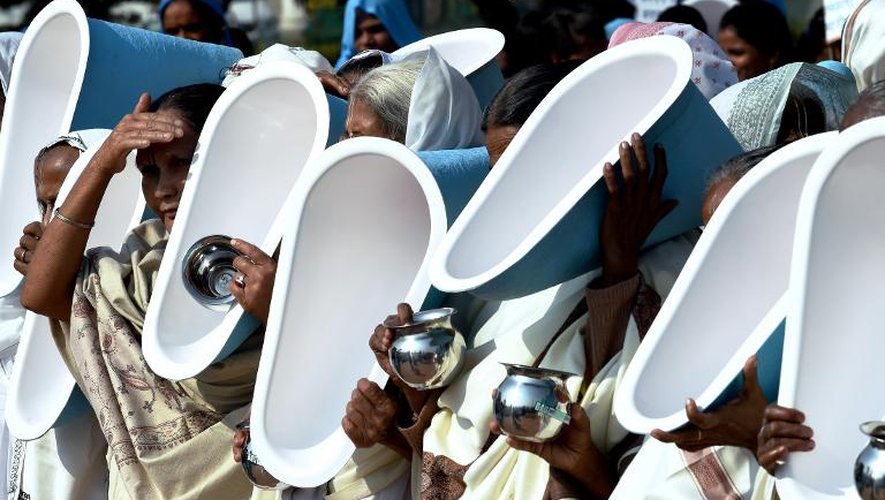 Des femmes indiennes brandissent des cuvettes lors d'un rassemblement à New-Delhi, le 18 novembre 2014, à la veille de la Journée mondiale des toilettes