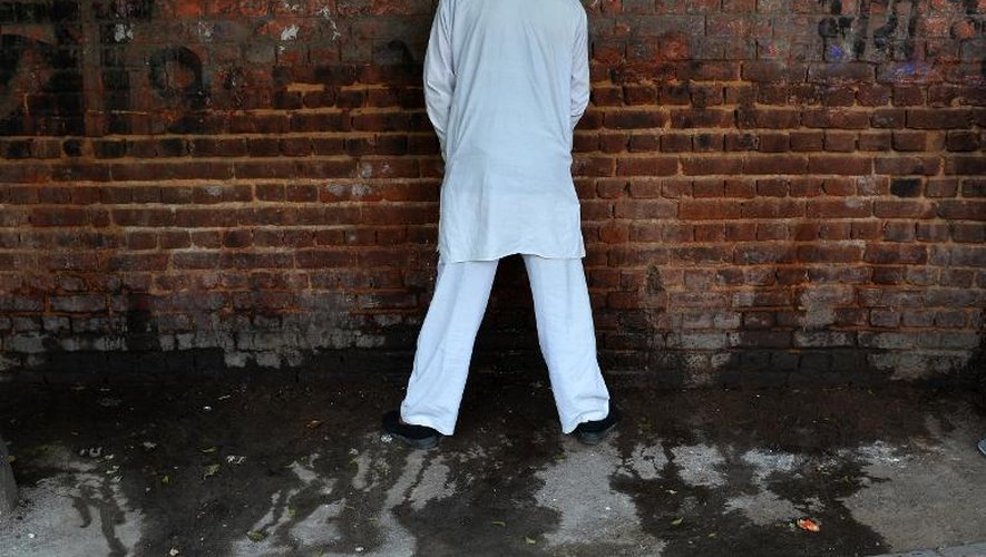 Un homme urine contre un mur dans une rue de New Delhi, le 18 novembre 2014, à la veille de la Journée mondiale des toilettes