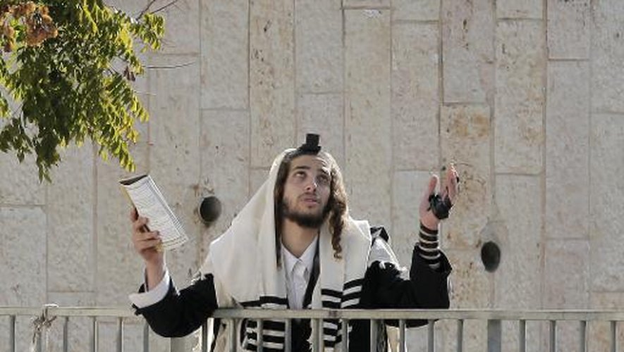 Un juif ultra-orthodoxe se lamente devant la synagogue de Jérusalem le 18 novembre 2014, quelques heures après l'attaque qui a fait 4 morts parmi les fidèles