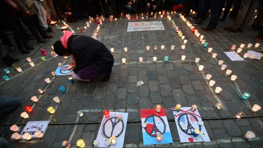 Sur la place communale, tracées à la craie sur les pavés, les lettres géantes de Molenbeek, accompagnées du symbole pacifiste "Peace & Love" et sur lesquelles repose un tapis de bougies, déposées par les habitants, le 18 novembre 2015