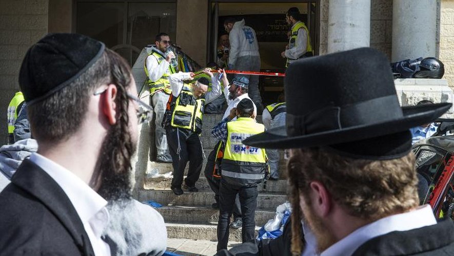 Des juifs ultra-orthodoxes et des équipes de secours israéliennes sur les lieux d'une attaque contre une synagogue, le 18 novembre 2014 à Jérusalem