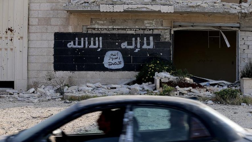 Le drapeau islamique peint sur le mur d'une entreprise détruite dans la zone industrielle d'Alep, le 18 novembre 2014 en Syrie