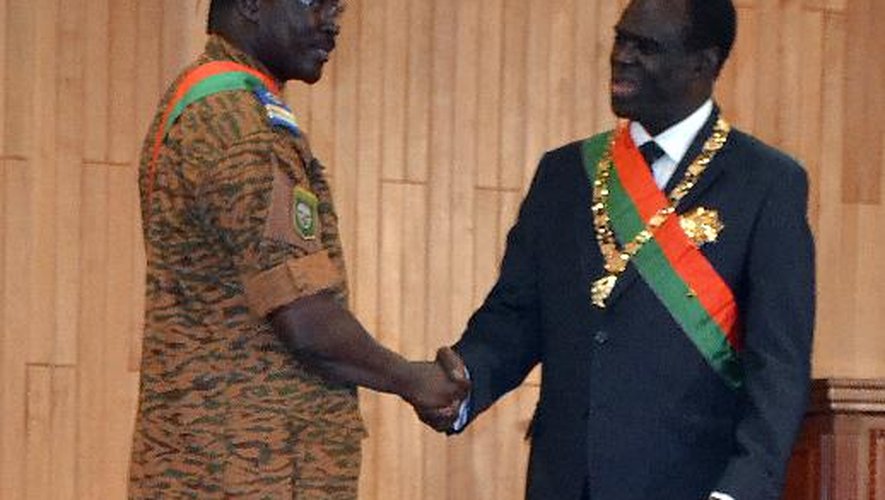 Michel Kafando (droite) serre la main du lieutenant Isaac Zida à Ouagadougou le 18 novembre 2014
