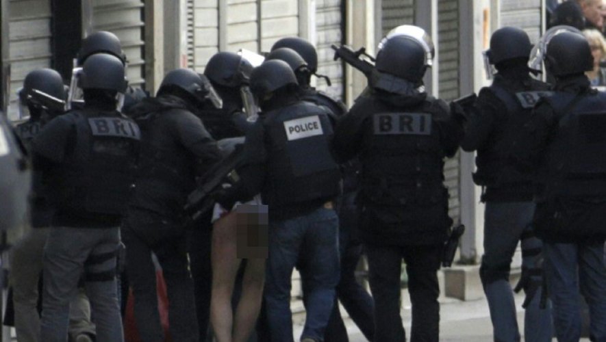 Des policiers de la BRI emmènent un homme après un assaut contre un appartement à Saint-Denis en lien avec les attentats de Paris, le 18 novembre 2015