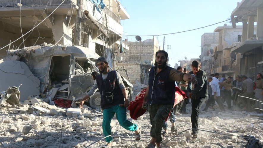 Des volontaires syriens transportent un blessé après des bombardements le 30 septembre 2016 sur la zone rebelle de Heluk à Alep