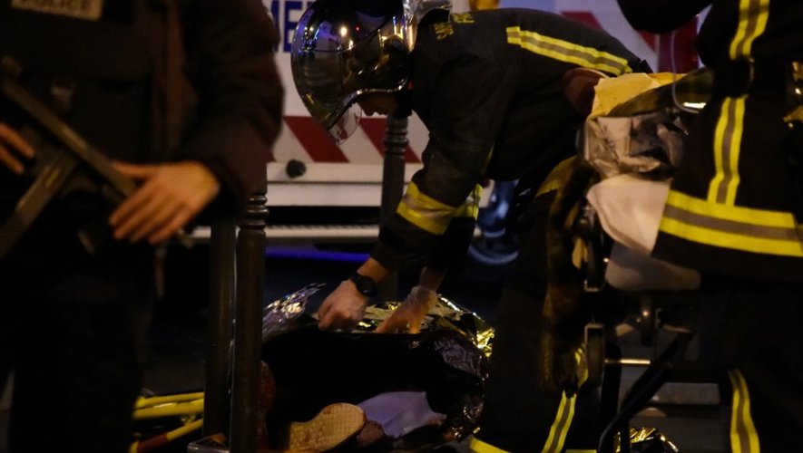Un pompier vient en aide à une personne blessée le 14 novembre 2015 lors de la prise d'otages au Bataclan, à Paris