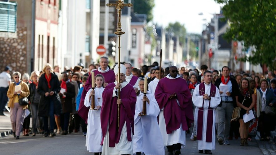 L'archevêque Dominique Lebrun en tête d'une procession dans une rue de Saint-Etienne-du-Rouvray le 2 octobre 2016, avant la messe marquant la réouverture de l'église où a été assassiné le père Hamel