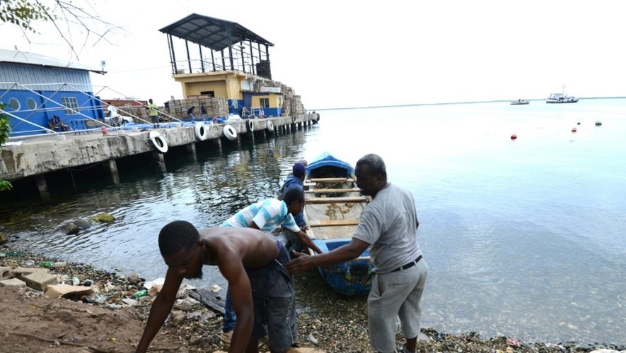 Des pêcheurs tirent un bateau pour le mettre à l'abri avant l'arrivée de l'ouragan Matthew à Kingston le 1er octobre 2016