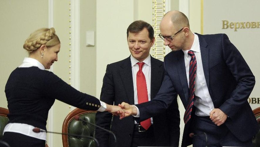Le Premier ministre ukrainien Arseni Iatseniouk (d) serre la main de Ioulia Timochenko, leader du parti Batkivchina (La Patrie), après la signature de leur coalition parlementaire, le 21 novembre 2014 à Kiev