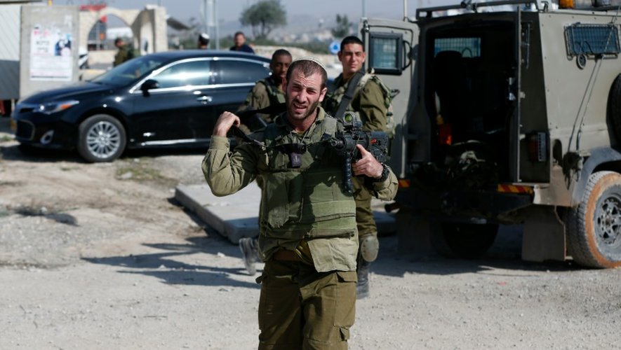 Des soldats israéliens près d'une voiture où une Palestinienne a tenté de poignarder un Israélien, en Cisjordanie le 22 novembre 201