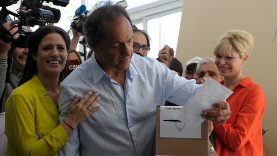 Le gouverneur de Buenos Aires et candidat à la présidentielle Daniel Scioli (C) met son bulletin dans l'urne le 22 novembre 2015 à Buenos Aires