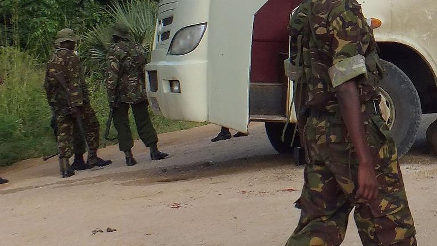 Des policiers kényans près d'un bus attaqué par des hommes armés à Witu, le 18 juillet 2014