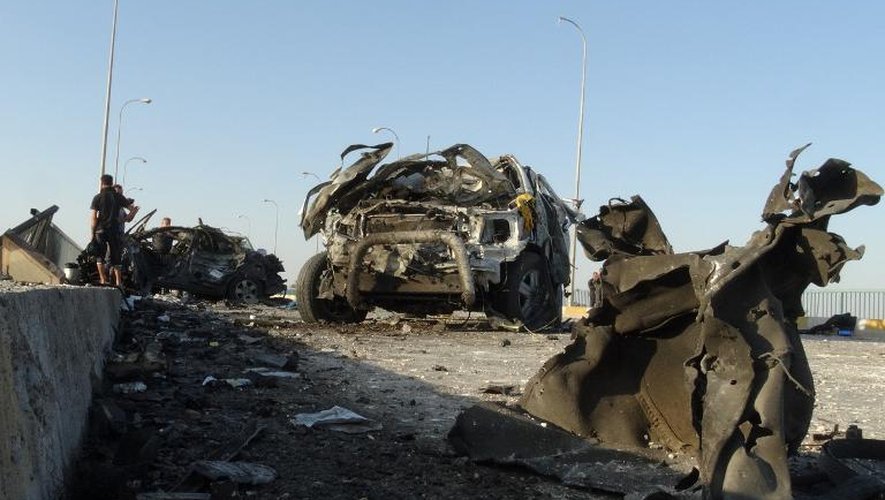 Des forces de sécurité irakiennes inspectent des carcasses de véhicules après un attentat suicide, le 17 septembre 2014 à Ramadi