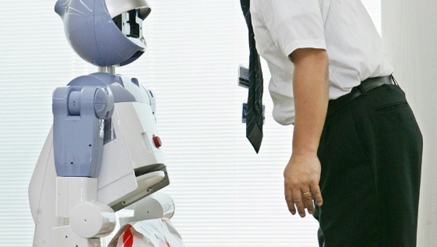 Le robot de service à la personne "Enon" développé par Fujitsu communique avec un ingénieur avant de transporter un paquet, à Tokyo le 13 septembre 2005