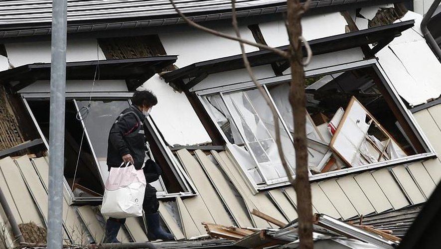 Une habitante de Hakuba venue récupérer des affaires dans les décombres de sa maison après un tremblement de terre, le 23 novembre 2014 dans la préfecture de Nagano, au Japon