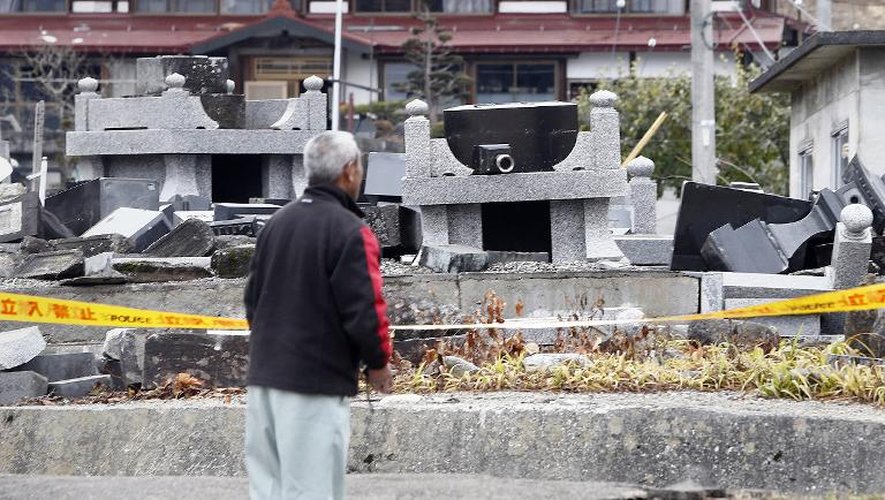 Un habitant de Hakuba regarde des tombes soulevées ou brisées après un tremblement de terre, le 23 novembre 2014 dans la préfecture de Nagano, au Japon
