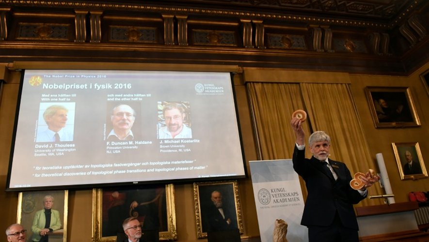 Thors Hans Hansson (D), membre du comité Nobel de physique utilise bagels et bretzels pour illustrer ses explications à propos du travail des trois lauréats du prix nobel de physique, le 4 octobre 2016 à Stockholm