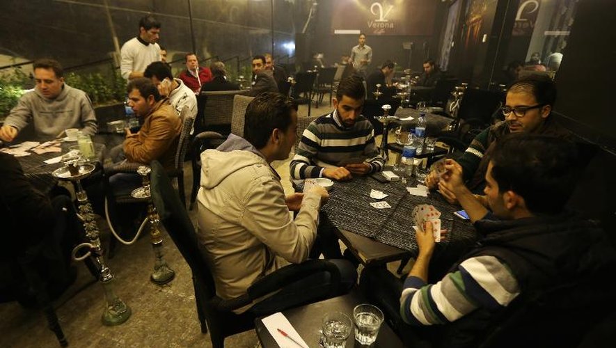 Des Syriens jouent aux cartes dans un café du quartier chic de Mogambo, en secteur gouvernemental, le 15 novembre 2014 à Alep