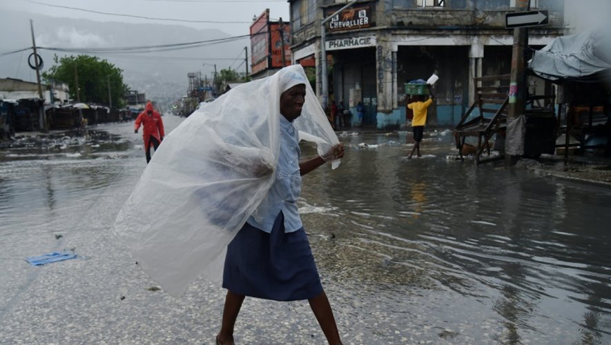Une femme se protège de la pluie avant l'arrivée de l'ouragan Matthew à Port-au-Prince, le 4 octobre 2016