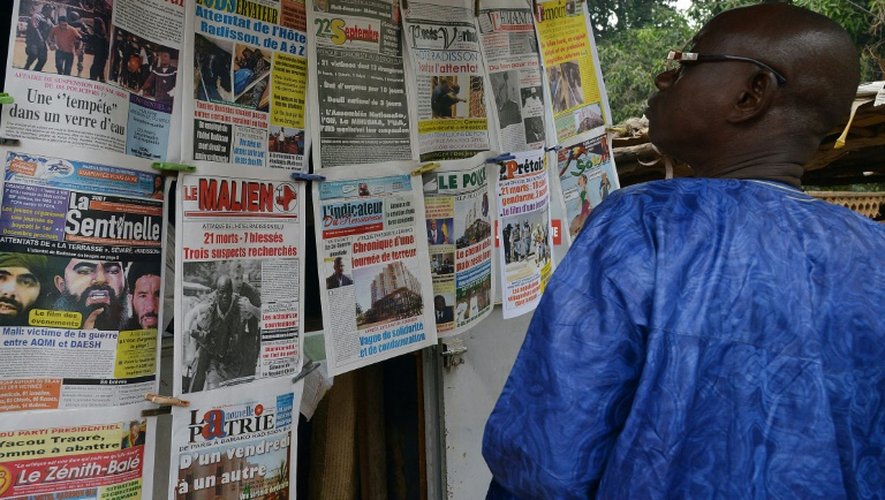 Un homme regarde les unes des journaux maliens, le 23 novembre 2015 à Bamako