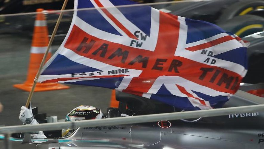 Le Britannique Lewis Hamilton avec le drapeau de l'Union Jack après avoir remporté le GP d'Abou Dhabi, le 23 novembre 2014