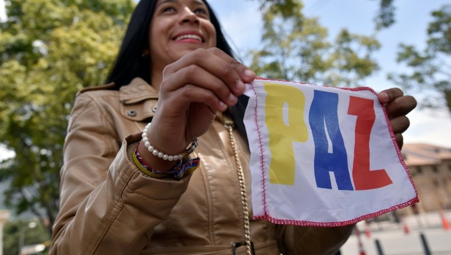 Une femme manifeste devant le palais présidentiel en brandissant le mot "paix", le 5 octobre 2016 à Bogota
