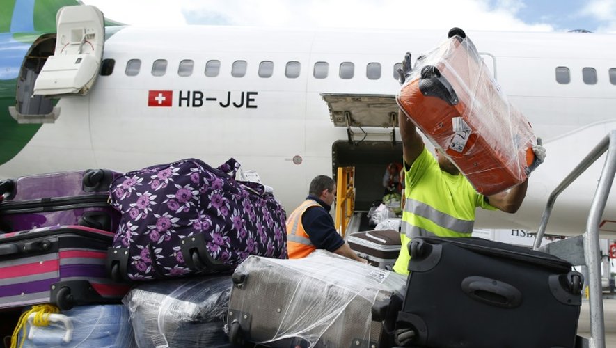 Des employés déchargent des bagages d'un avion à l'aéroport de Roissy le 18 août 2014