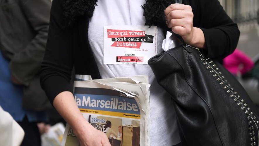 Une femme tient un exemplaire de la Marseillaise devant la Palais de justice de Marseille le 24 novembre 2014