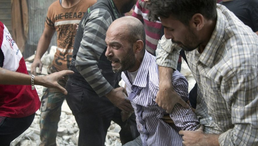 Un habitant d'Alep-Est crie sa douleur alors que les secouristes extraient le corps de sa fille des décombres d'un bâtiment touché par une frappe aérienne, le 27 septembre 2016